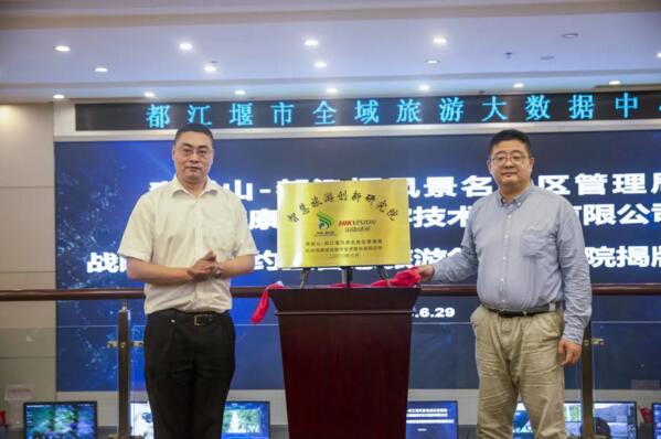 江堰市委常委、宣傳部部長(zhǎng)唐小峰與?？低暩呒?jí)副總裁徐習(xí)明為“智慧旅游創(chuàng)新研究院”揭牌